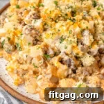 Top down look at ground beef and potato casserole plated on a round inner plate and topped with chopped parsley.