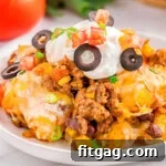 A piece of mexican tater tot casserole on a white plate.