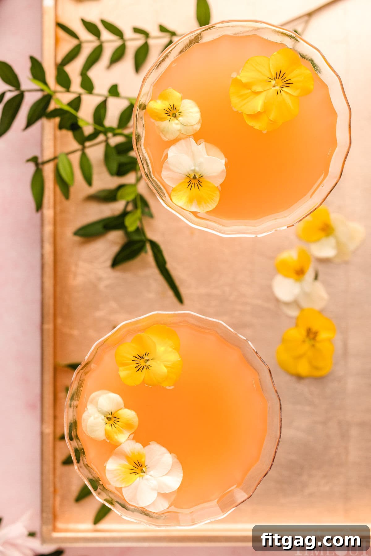 A top-down composition of French Blonde Cocktails presented in glasses on a metallic tray, surrounded by their key ingredients and garnishes.