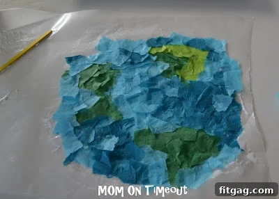 The second half of the wax paper is folded over the tissue paper design, sealing it.