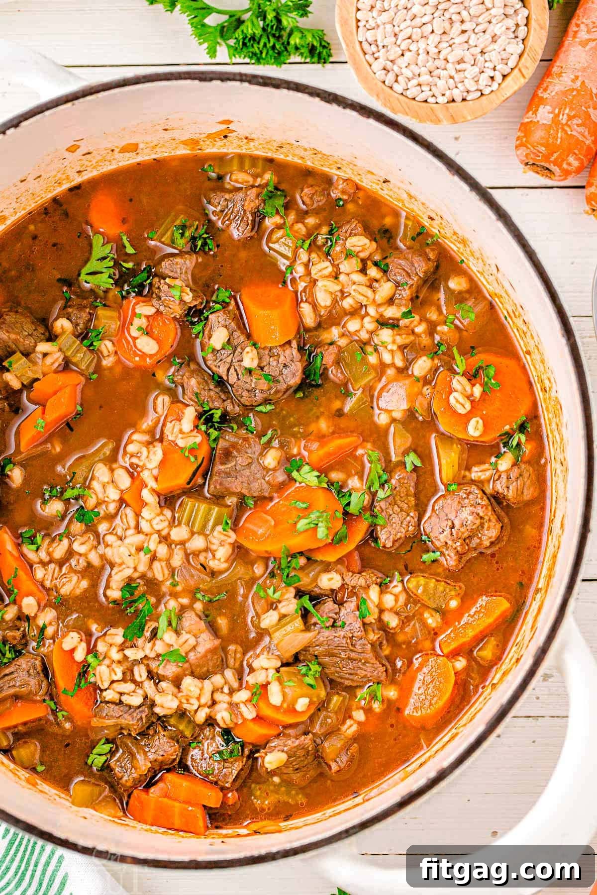 Hearty Beef and Barley Comfort Bowl 3 A top down shot of beef and barley soup in a white dutch oven.