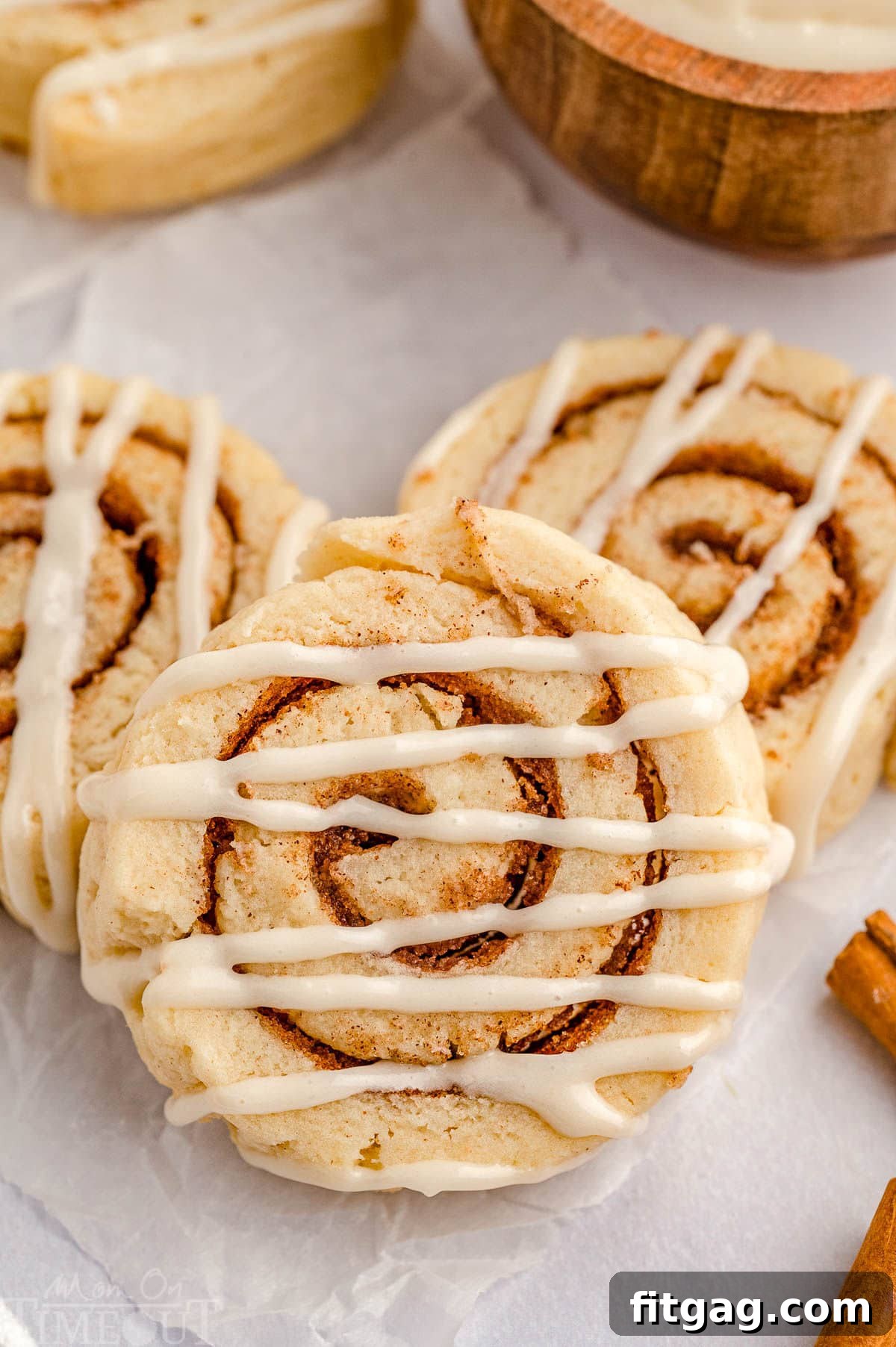 Cinnamon Swirl Delights 2 Top down shot of cinnamon roll cookies on parchment paper.
