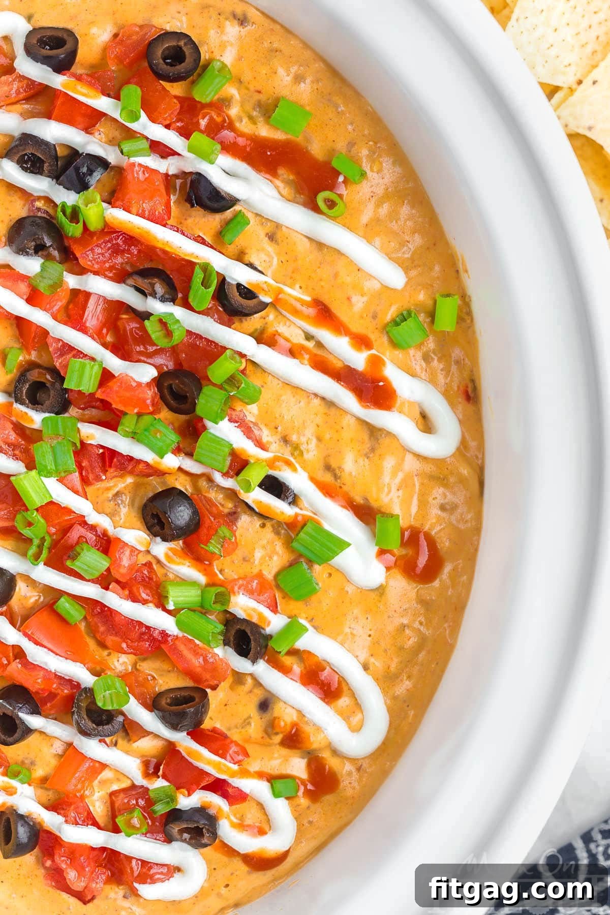 Warm and Cheesy Slow Cooker Taco Dip 2 Top down view of crockpot taco dip in a white crockpot insert.