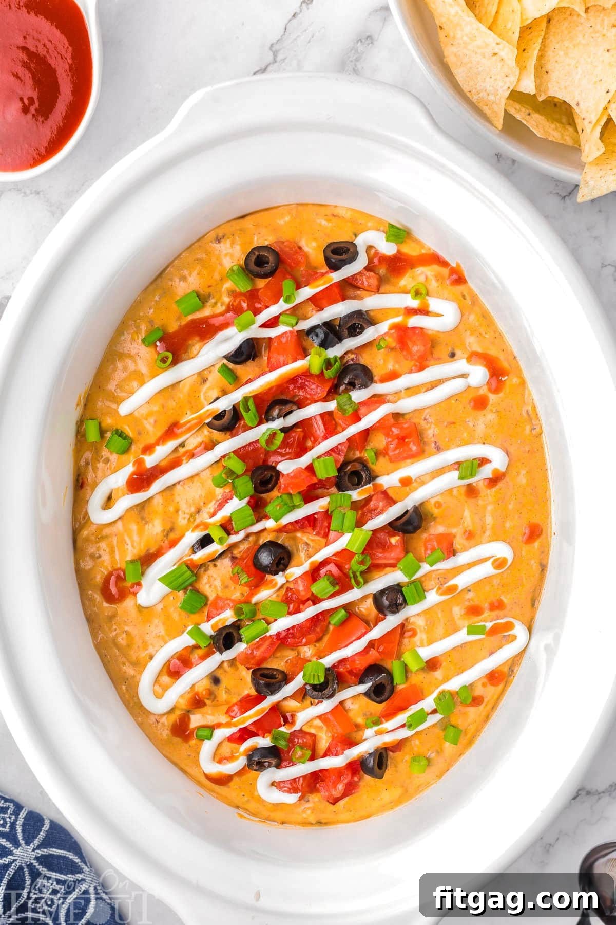 Warm and Cheesy Slow Cooker Taco Dip 8 Top down view of crockpot taco dip in a white crockpot liner.