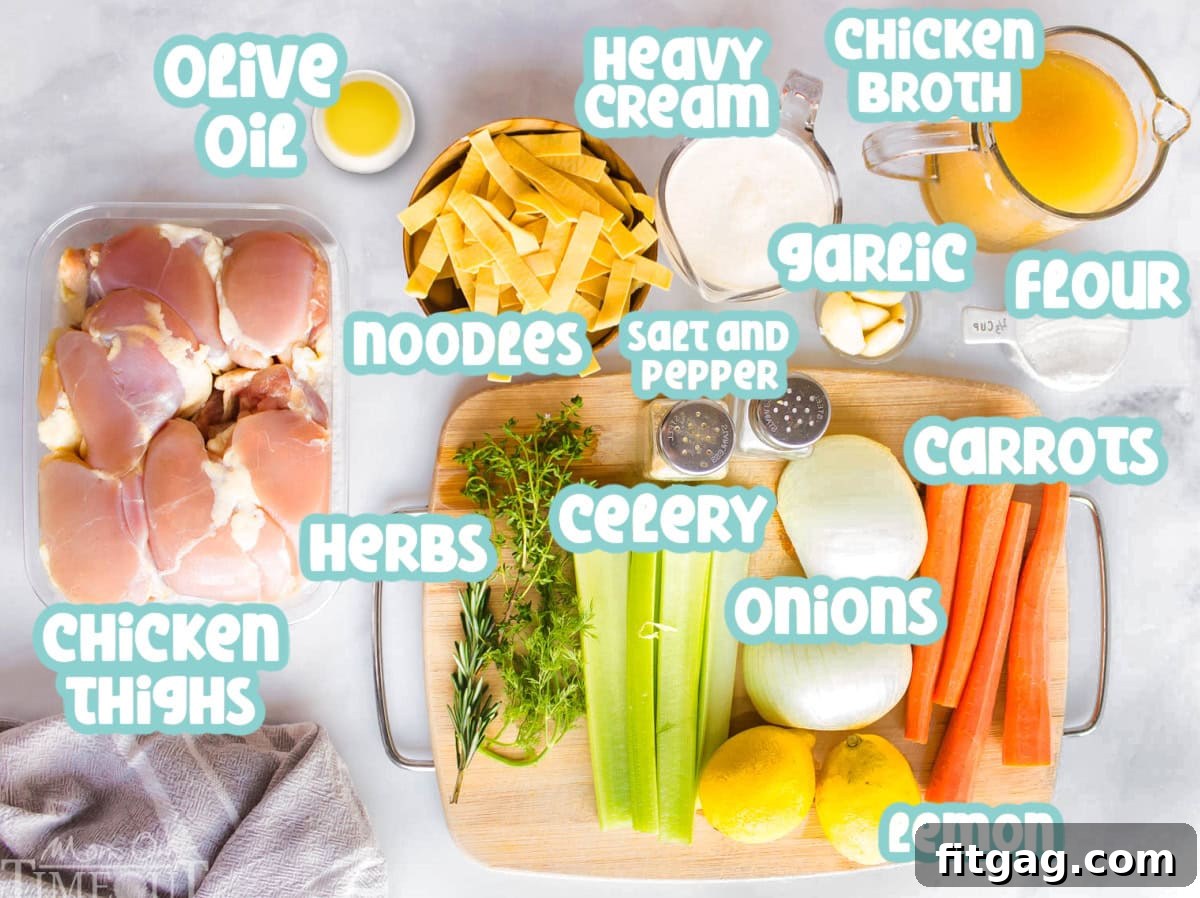 A flat lay image displaying all the fresh ingredients for creamy chicken noodle soup, including diced vegetables, raw chicken, chicken broth, heavy cream, and fresh herbs.