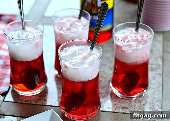 Close-up of a Cherry Italian Cream Soda, showing the layers of syrup, soda, and cream with ice