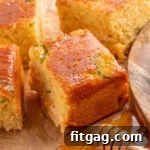 Spicy Cornbread Kick 8 Jalapeno Cornbread recipe cut into squares on parchment paper with honey dripping onto the paper.