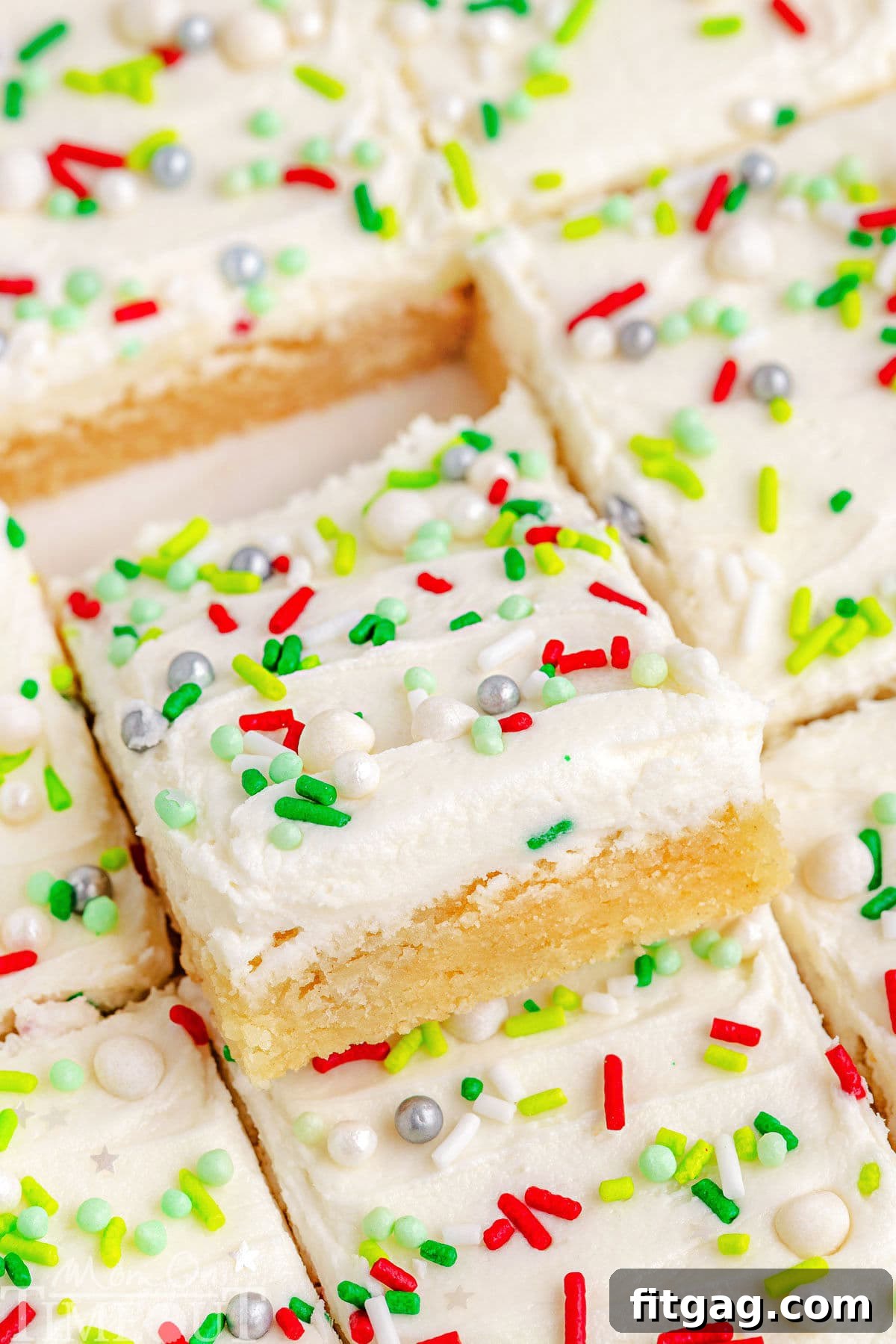 Festive Frosted Sugar Cookie Bars 3 A perfectly cut Christmas Sugar Cookie Bar, showing off its thick layer of frosting and sprinkles, ready to be enjoyed.