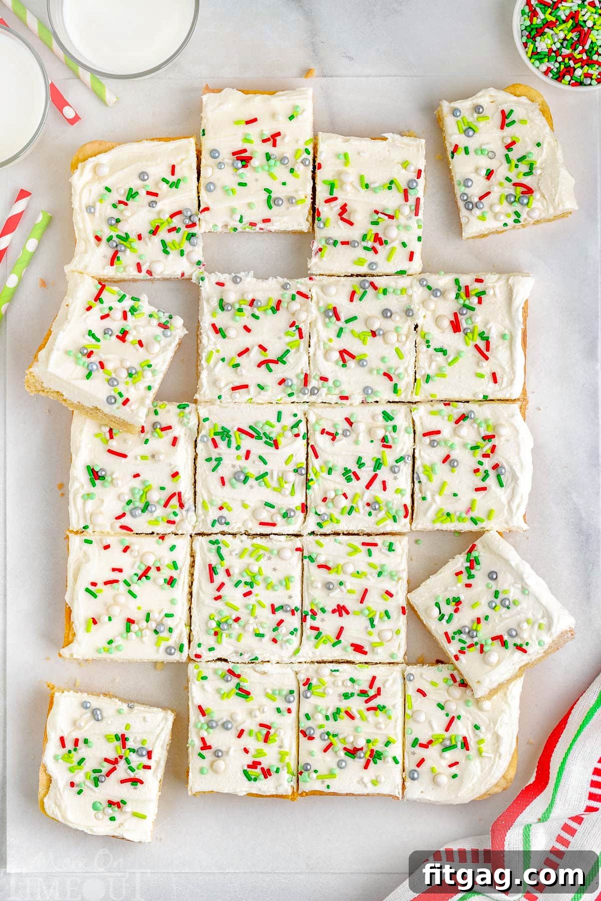 Festive Frosted Sugar Cookie Bars 6 A top-down view of beautifully cut sugar cookie bars arranged on parchment paper, highlighting their perfect squares and inviting appearance.