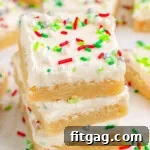 Festive Frosted Sugar Cookie Bars 10 Three Christmas Sugar Cookie Bars in a stack with more bars in the background.