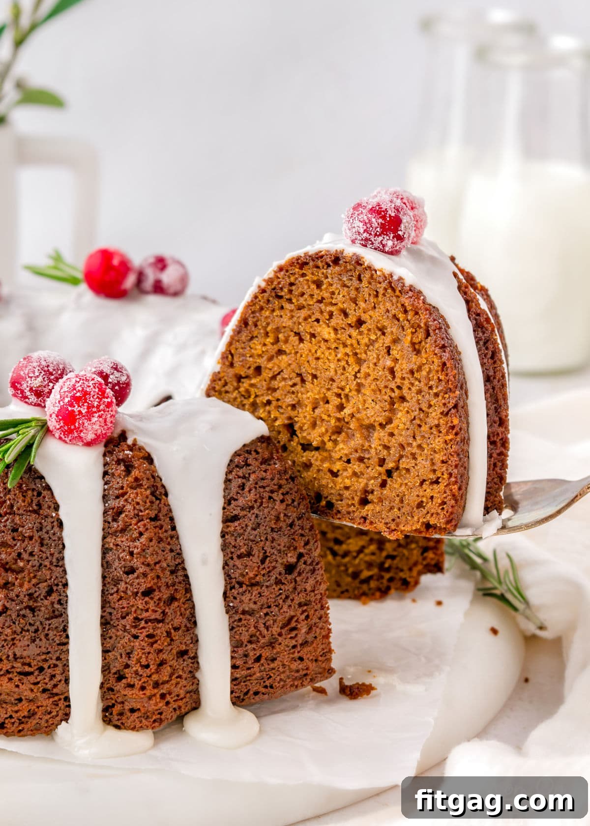 A spatula holding a piece of gingerbread bundt cake above the rest of the cake.