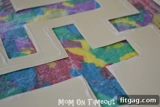 Applying a thin line of glue around the perimeter of the paper cross template