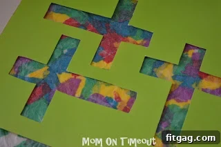 Gluing the paper cross template onto the dried stained glass wax paper