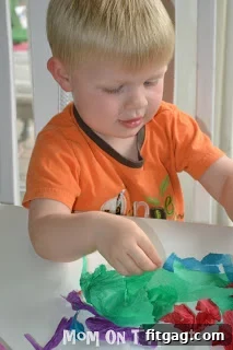Child's hands tearing colorful tissue paper