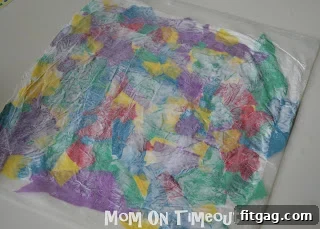 Smoothing down the wax paper and tissue paper layers to remove air bubbles