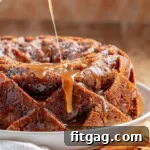 Caramel glaze being drizzled on top of the apple bundt cake.
