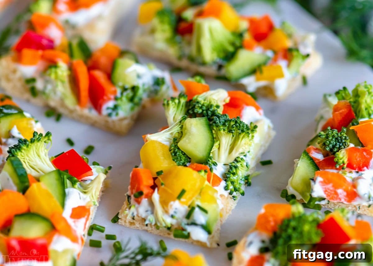 Party-Perfect Veggie Pizza Bites 4 Close-up view of freshly cut veggie pizza pieces, artfully arranged on a sleek marble serving board, highlighting the vibrant colors and appealing texture.