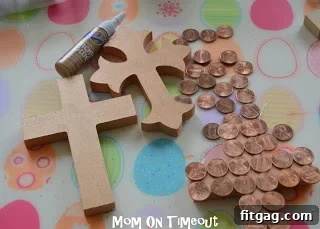 Wooden crosses being painted with copper metallic paint, preparing the base for the coin application in the Easter craft.