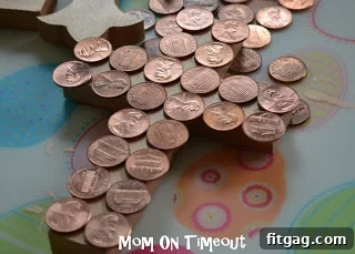 Arranging coins on a painted wooden cross, planning the design before gluing for the Easter craft.