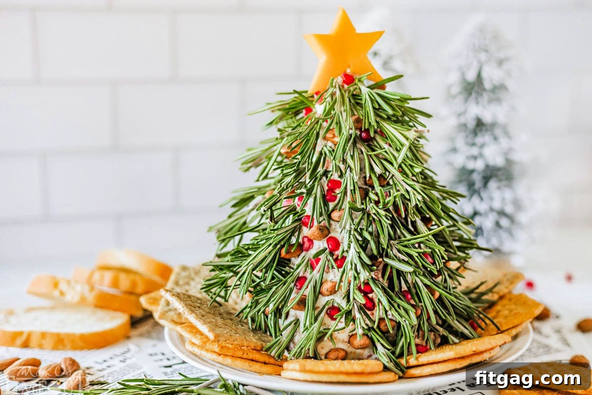 Christmas Tree Cheese Ball on a white plate with crackers surround it. Cheese ball is topped with a cheddar cheese star.