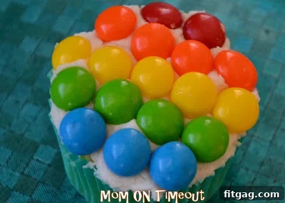 Vibrant Rainbow Bites 11 Hand holding a colorful rainbow cupcake