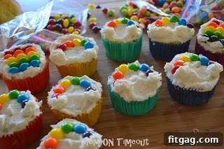 Vibrant Rainbow Bites 5 Child's hands decorating a rainbow cupcake with Skittles