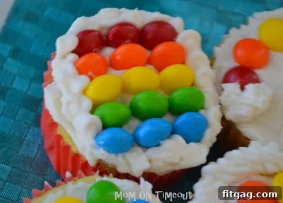 Collection of rainbow cupcakes with different candy arrangements