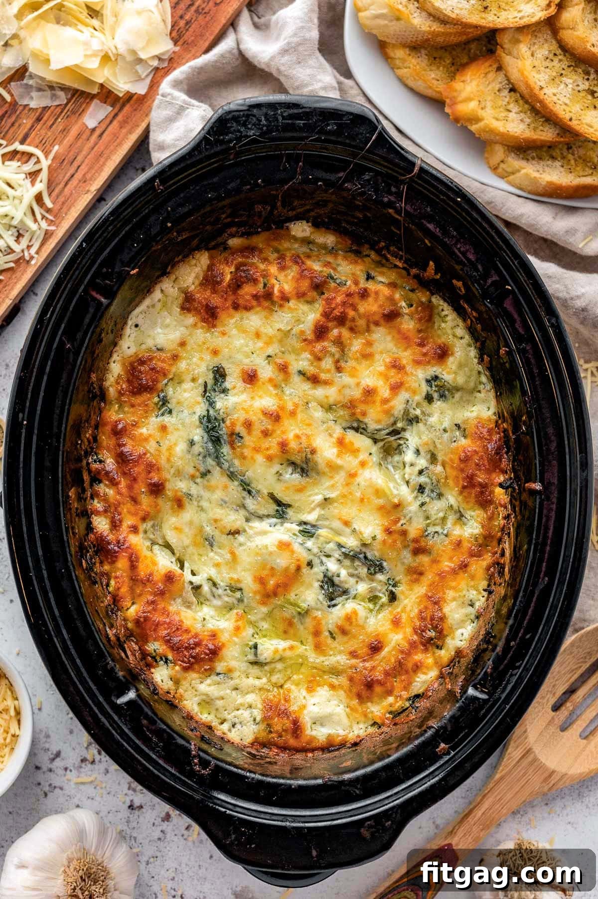 One Pot Wonder Spinach Artichoke Dip 5 Top-down view of bubbly, warm spinach artichoke dip simmering in a crockpot, ready to be served.