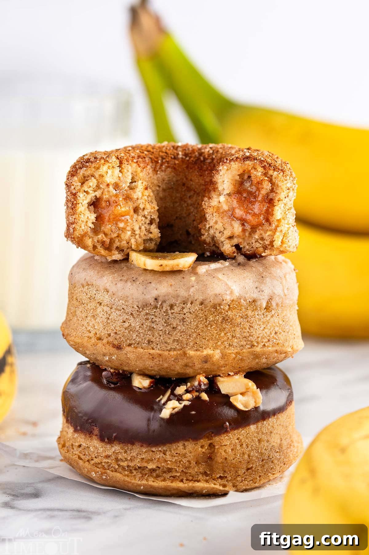 Banana Bliss Donuts 3 Banana Donuts stacked on top of each other. Bananas are in the background.
