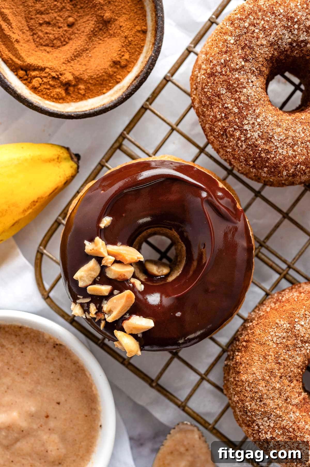 Banana Bliss Donuts 7 Chocolate glazed banana donut on cooling rack to cinnamon sugar banana donuts.