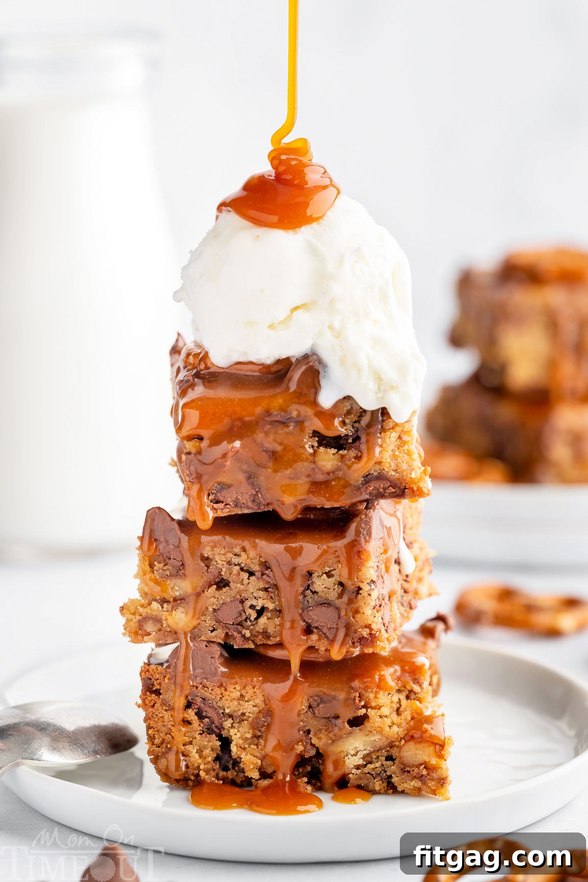 A stack of blondies with a scoop of vanilla ice cream and salted caramel sauce drizzled on top.