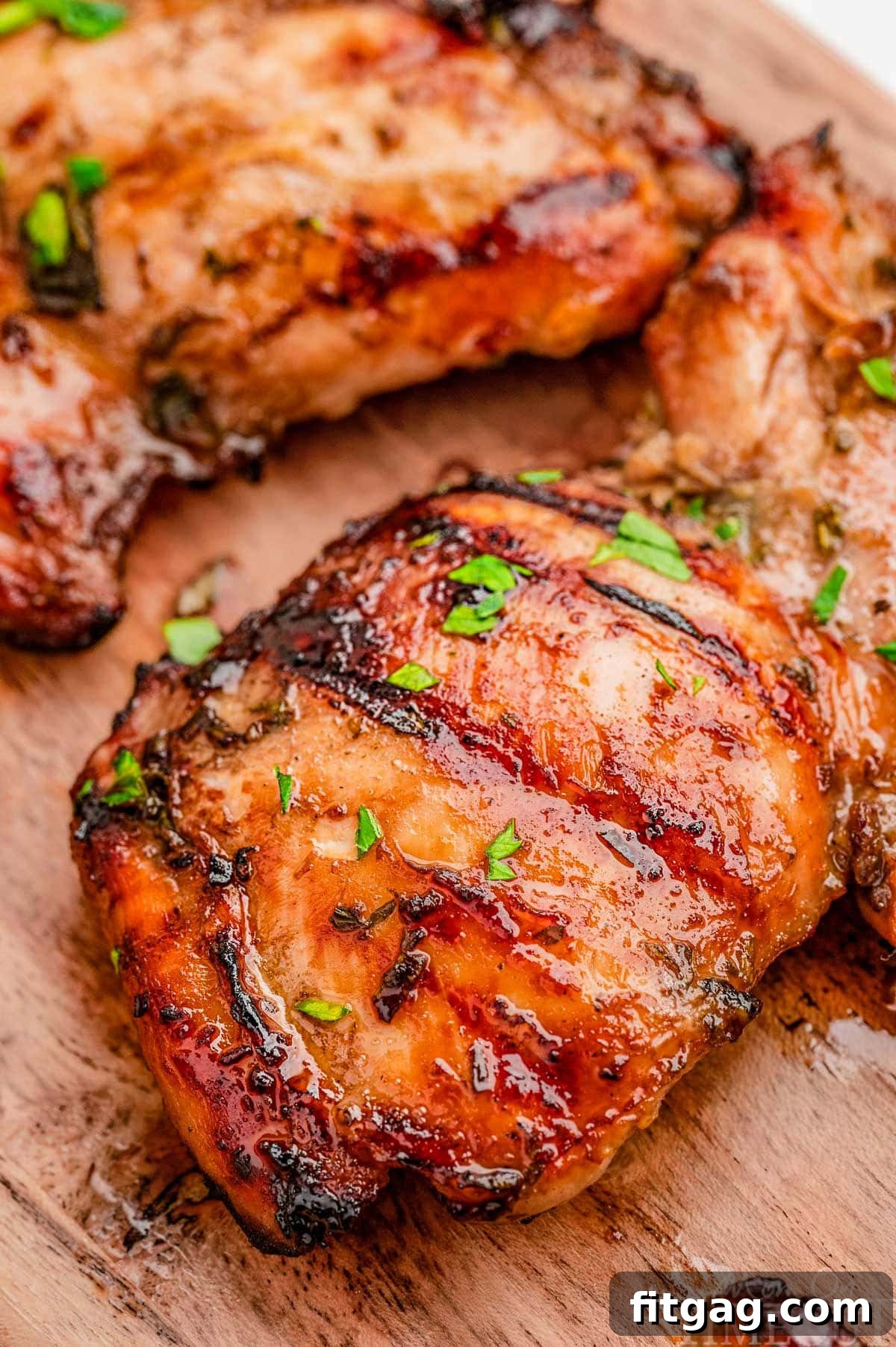 Grilled balsamic chicken marinated in balsamic chicken marinade sitting on wood board.