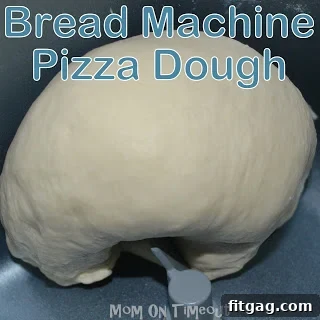 Bread machine kneading pizza dough to perfect consistency.