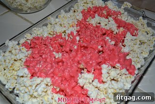 Sweet Valentine's Popcorn Balls 7 Drizzling the warm marshmallow mixture over the popcorn in the baking dish.