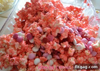 Sweet Valentine's Popcorn Balls 8 Hands mixing popcorn and marshmallow, with M&Ms ready to be added.