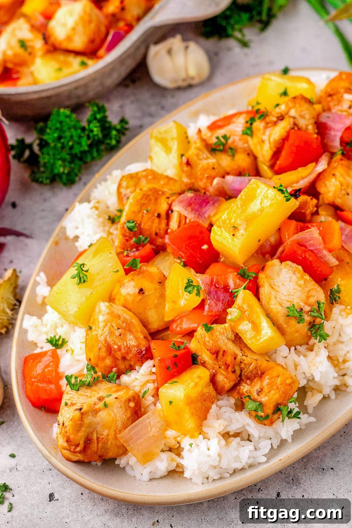 Close up look at Hawaiian Chicken recipe plated with rice on an oval plate. A vibrant and appealing dish featuring juicy chicken, colorful bell peppers, and sweet pineapple chunks, perfectly glazed and ready to serve.