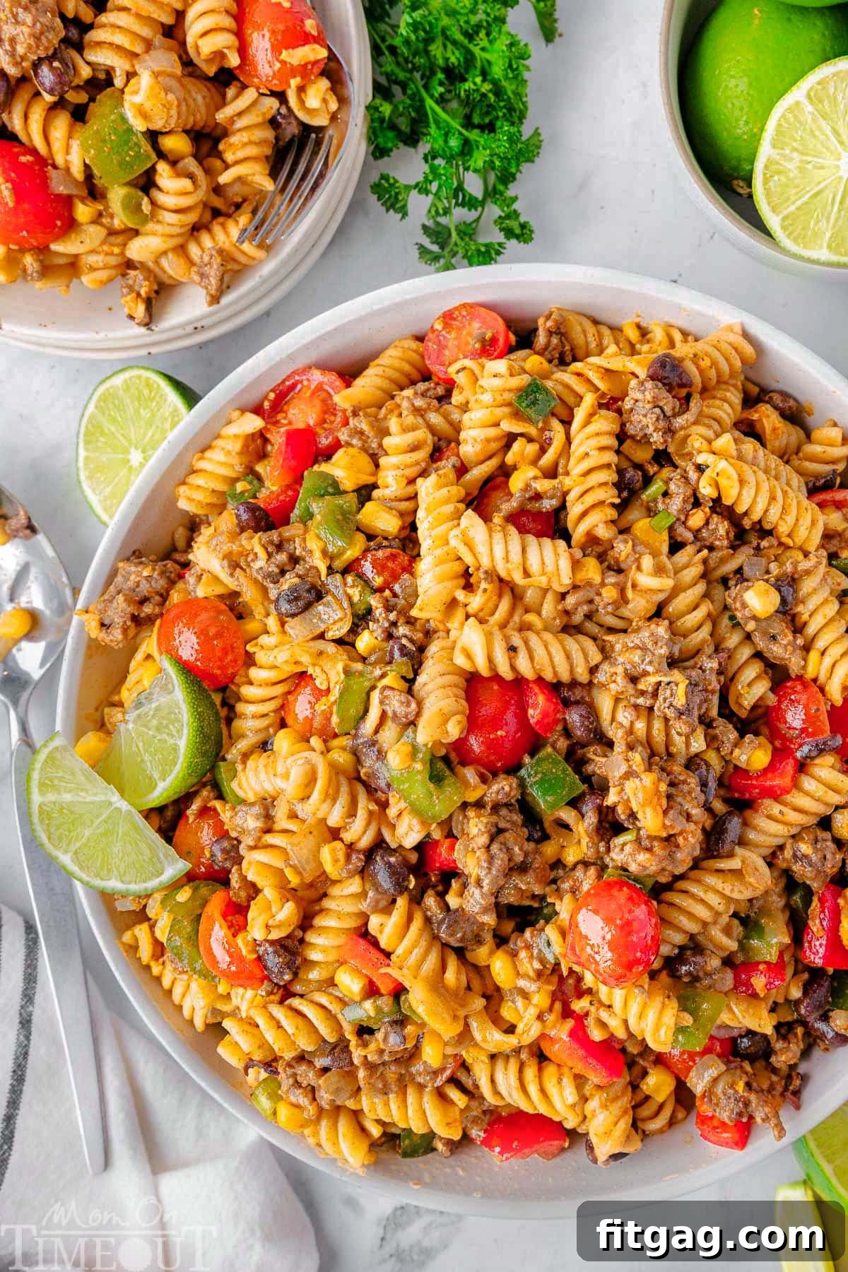 Chuckwagon Pasta Salad 3 An overhead shot showcasing two-thirds of a large bowl of Cowboy Pasta Salad. The salad features a colorful mix of ingredients including ground beef, black beans, vibrant fresh vegetables, and a tantalizing taco-lime dressing.
