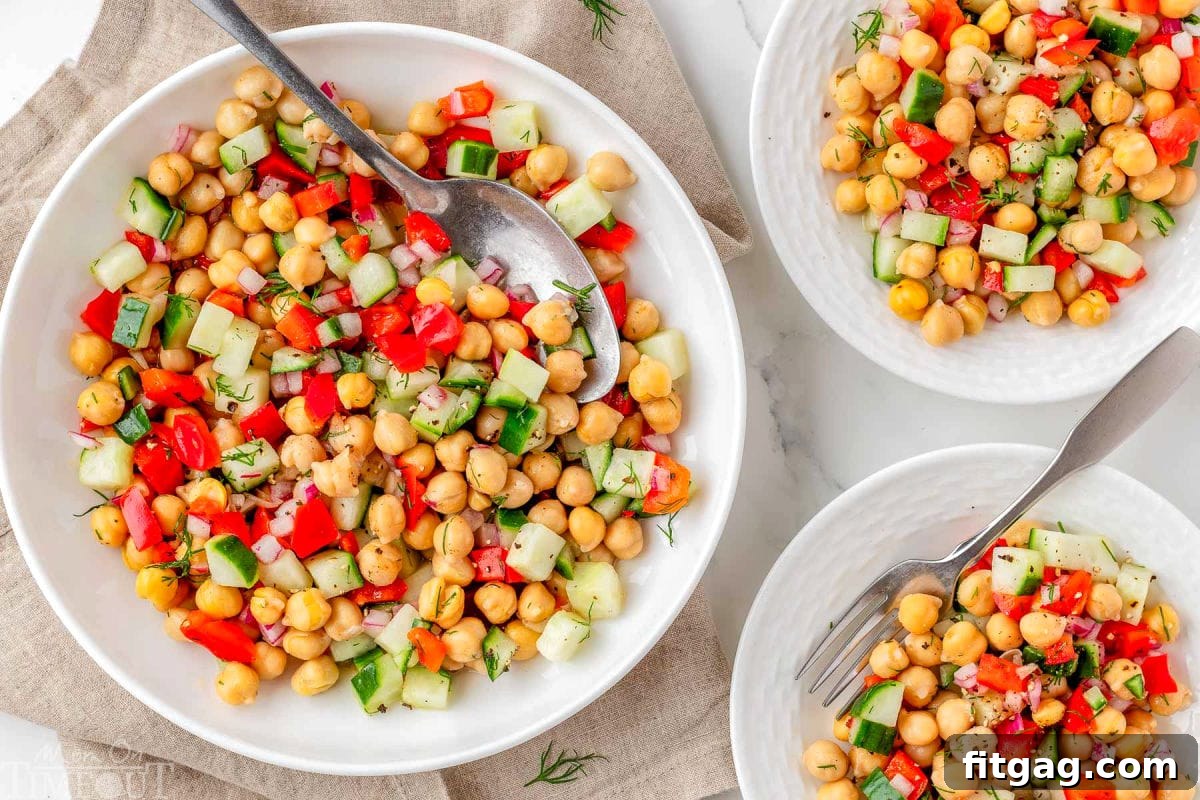 A wide shot showcasing three individual plates, each perfectly portioned with a serving of chickpea salad, ready to be enjoyed.