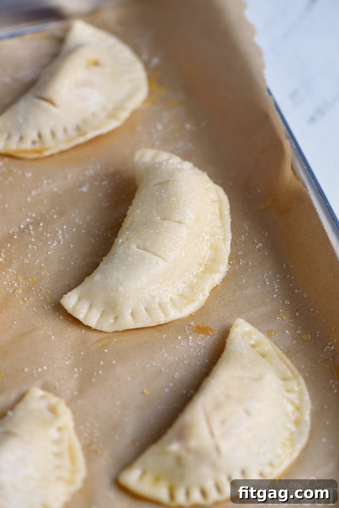 Pie dough rounds sprinkled with sugar, ready for filling.