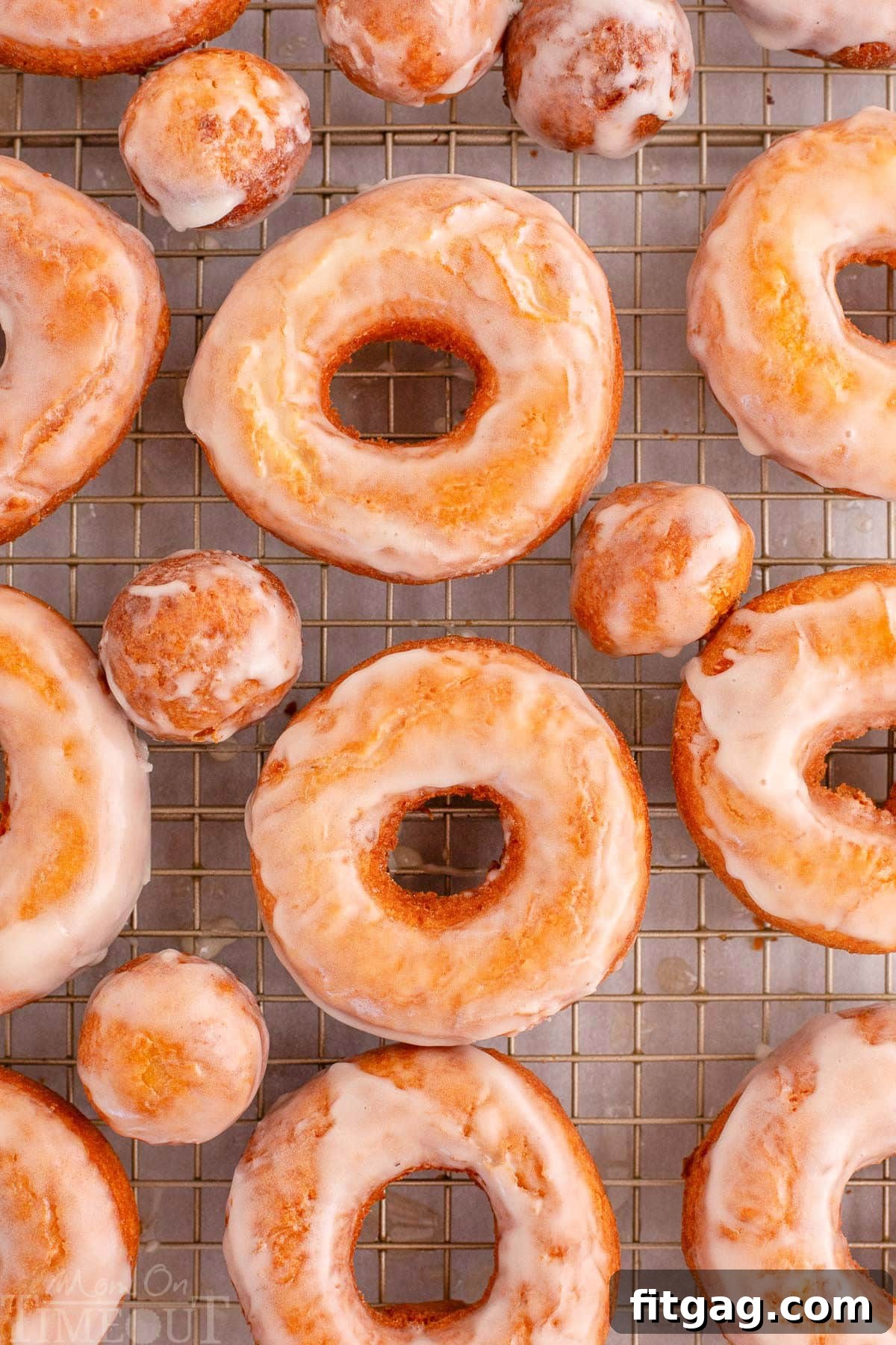 Overhead shot of sour cream cake donut on wire rack topped with glaze. 