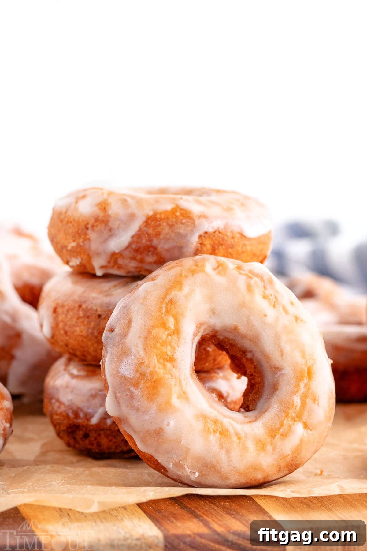 Donuts stacked three high with one glazed cake donut leaning against the stack.
