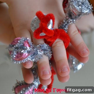 A child's hand proudly wearing a red Hershey's Kiss ring, sparkling brightly.