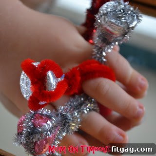 A child's hand showing off a silver Hershey's Kiss ring, resembling a diamond.