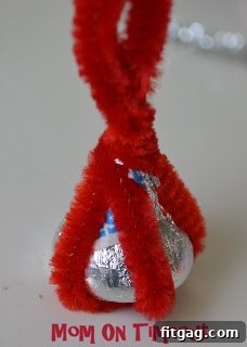 Pipe cleaner ends separated into two pairs, extending from either side of the Hershey's Kiss.