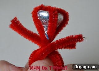 Twisting the pipe cleaner ends together at the top of the ring to secure the band and trimming excess for safety.