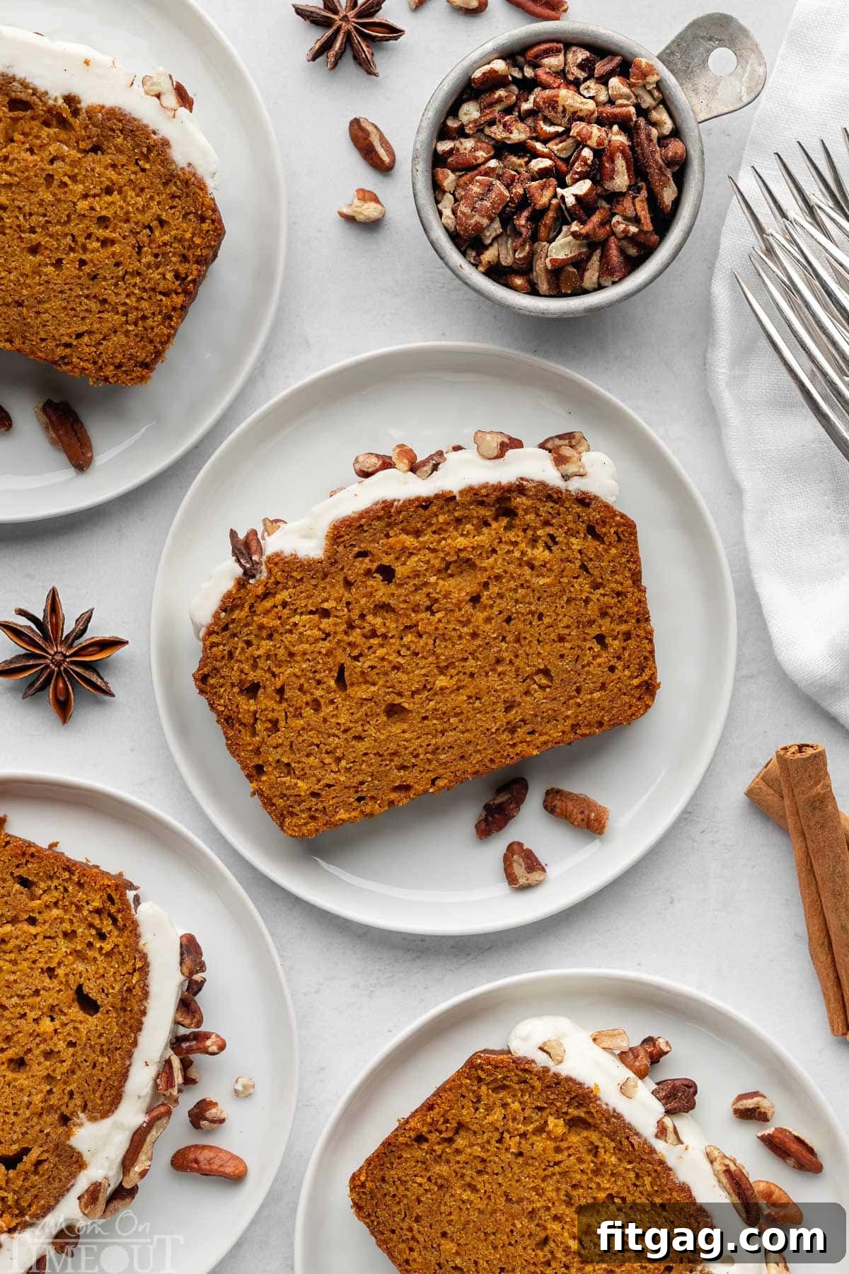 Overhead shot of recipe for pumpkin bread cut into slices and plated. Four plates shown.
