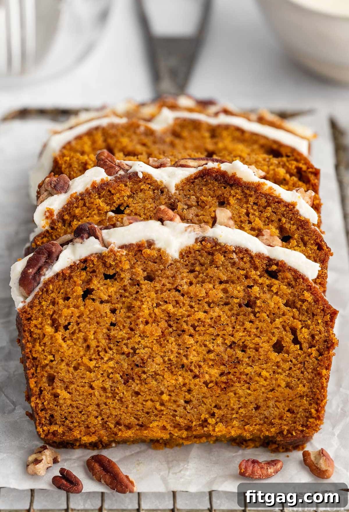 Three slices cut from pumpkin loaf recipe sitting on board. 