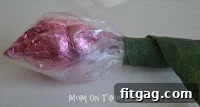Securing the Hershey's Kiss rosebud to the stem with floral tape