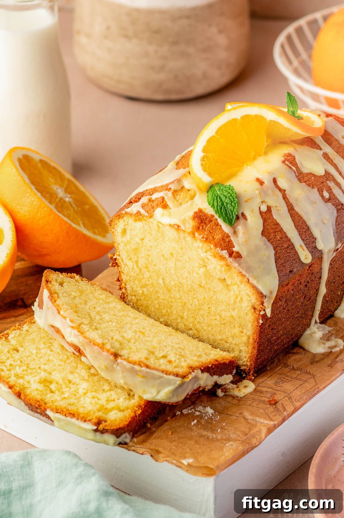 Top-down view of a glazed Orange Pound Cake on a cutting board, with two inviting slices already cut.