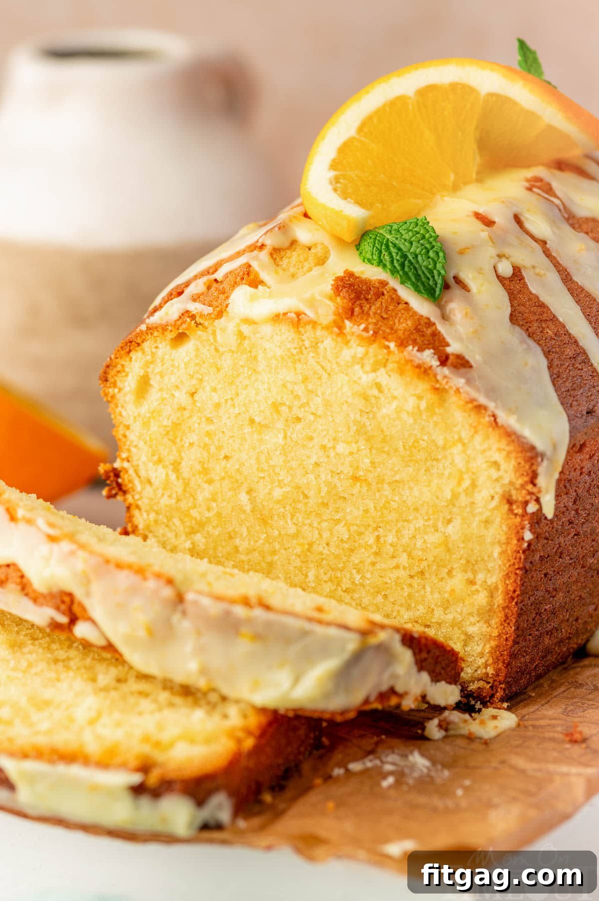 Bright Orange Loaf 8 Angled shot of orange pound cake on cutting board with two slices cut off.